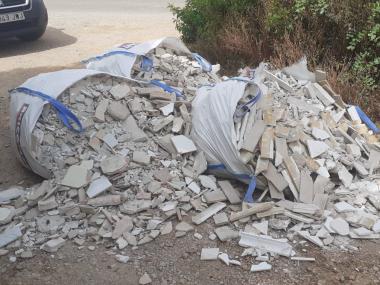 Quatre saques d'enderrocs tirades enmig del camí