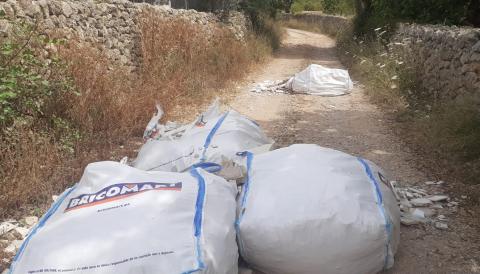 Quatre saques d'enderrocs tirades enmig del camí